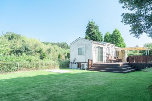 a tiny house in a yard with a lawn at なかやまHouse in Sumoto