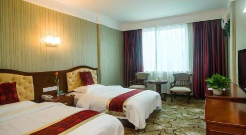a hotel room with two beds and a table at GreenTree Alliance Zhejiang Zhoushan Putuoshan Zhujiajian Scenic Spot Hotel in Zhoushan