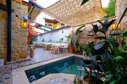 un patio al aire libre con piscina, mesas y plantas en Saye Konak Hotel ' Kaleiçi&Oldtown', en Antalya