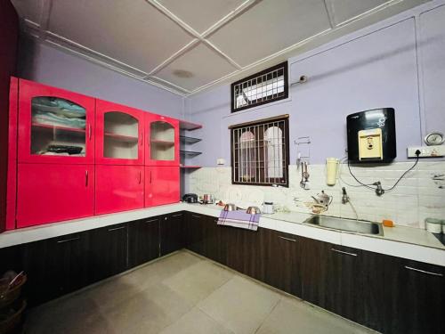 eine Küche mit roten Schränken und einer Spüle in der Unterkunft Serene Stays in Jorhat