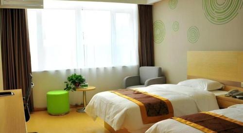 a hotel room with two beds and a chair at GreenTree Inn Liaocheng Donge Culture Street Express Hotel in Liaocheng