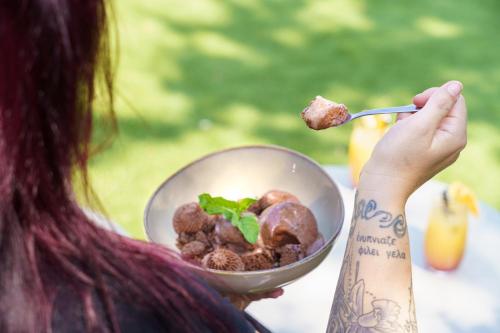 a woman eating a bowl of food with a fork at Brit Hotel Confort Manosque Cadarache in Manosque