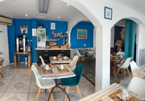 une salle à manger avec des murs bleus et une table et des chaises dans l'établissement Hotel Alcyon, à Valras-Plage