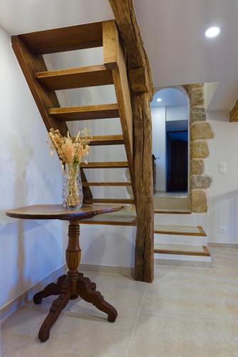 a table with a vase on it in a room with stairs at Mas des quatre cyprès in Spéracèdes
