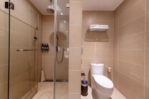 un bagno con wc e doccia in vetro di Guangzhou Baiyun Airport Orange Crystal Hotel a Huadu