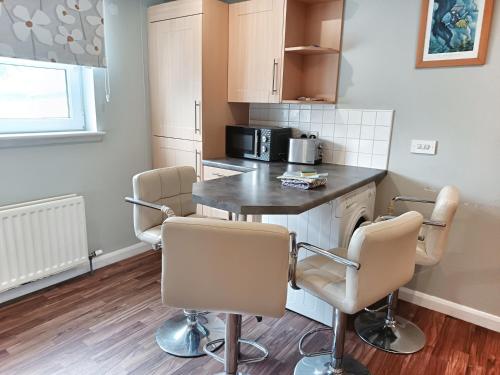 a kitchen with a table and chairs in a room at Spacious Ground floor, 2 bed by Lains Lettings m in Aberdeen