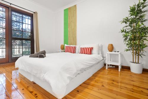 a bedroom with a white bed and a potted plant at 2-Bedroom House-Near city center Good for 6 Guests in Sydney