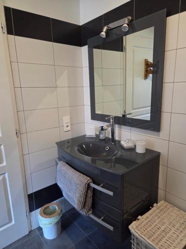 a bathroom with a black sink and a mirror at Un cocon de détente entre mer et nature in Zonza