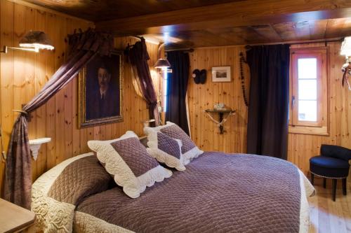 a bedroom with a bed in a room with wooden walls at Hôtel Bella Tola & SPA in Saint-Luc