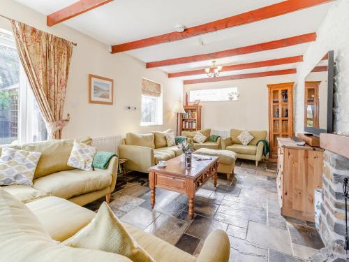 Una sala de estar con sofás y chimenea. en Llys Aber, en Solva