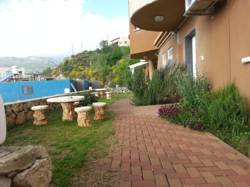 un passaggio pedonale in mattoni accanto a un edificio con tavoli e fiori di Sanabl Druze Hospitality a Ein Kinya