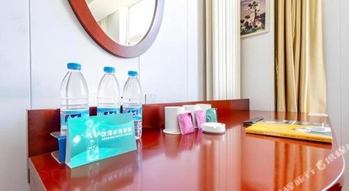 two bottles of water sitting on a wooden table at GreenTree Inn Yinchuan Pedestrian Street East Liqun Street Express Hotel in Yinchuan