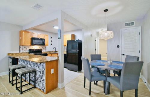 a kitchen and dining room with a table and chairs at Coastal Shores Condo in Biloxi