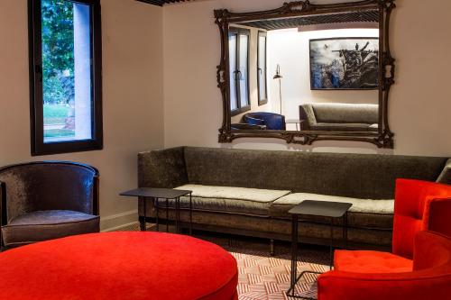 a living room with a couch and two chairs and a mirror at Hotel Luciano K in Santiago