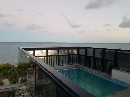 a swimming pool on a balcony overlooking the ocean at Apartment NEO 1.0 in Maceió