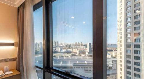 a window in a hotel room with a view of a city at Dalian Bohai Pearl Hotel in Dalian