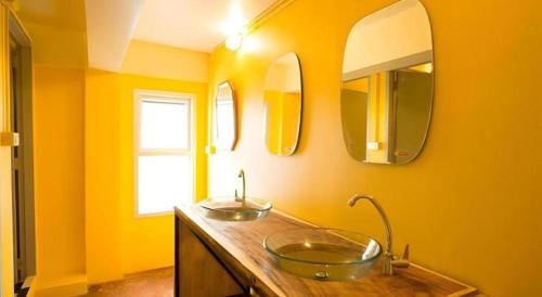 a bathroom with a sink and two mirrors at Oldie and Sleepy Hostel in Udon Thani