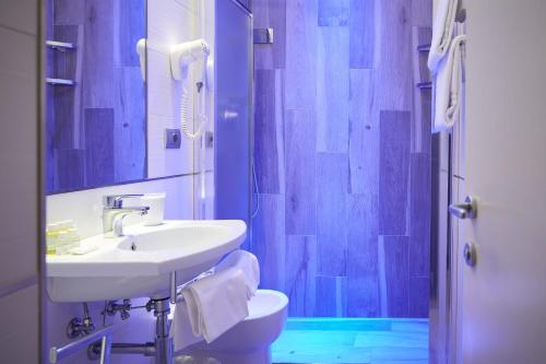 Un baño con lavabo, inodoro y ducha. en Hotel Cosimo de' Medici, en Florencia