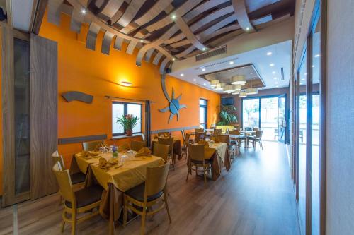 un restaurante con paredes amarillas, mesas y sillas en Hotel Sole en Maiori