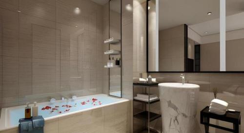 a bathroom with a bath tub and a sink at Yuan Culture Hotel Shenzhen World Shajing in Shenzhen