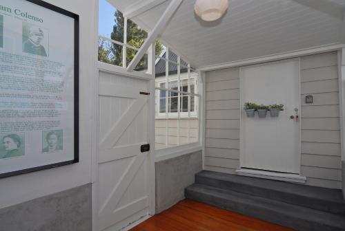 a door in a room with a window and a sign at Historic Colenso Cottage in Napier