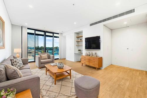 a living room with a couch and a tv at Prime Location for an Event in Olympic Park in Sydney