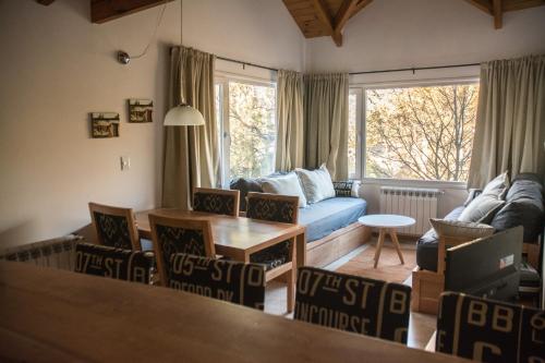 a living room with a couch and a table at Altos de la Montaña in San Martín de los Andes