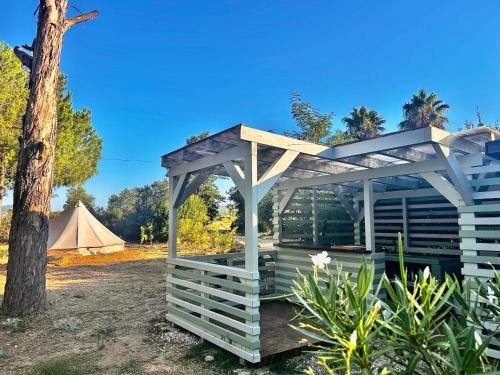a white pergola with a tent in the background at Glamping with Yoga and Natural Pool near Fuseta Beach in Moncarapacho