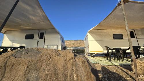 a tent and tables and chairs in front of a trailer at אגס תיירות קרוואנים חוף שיזף בכנרת in Kinneret