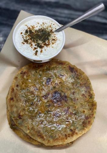 Un plato de comida con una pizza y un tazón de sopa. en Krishnam Homestay, en Jaipur
