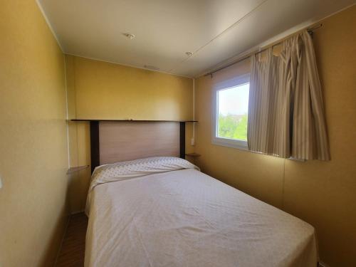 a small bedroom with a bed and a window at Camping Albox in Albox