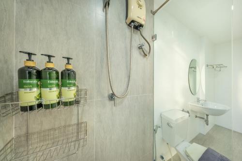 a bathroom with a shower and a toilet and a sink at SHIN Patara Living Hotel in Bangkok