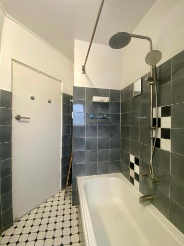 a bathroom with a bath tub and a shower at Coastal Retreat- Beach, Lagoon & Cafes Just Steps from Your Door! in Narrabeen