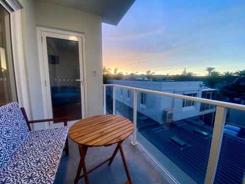 a balcony with a table and a chair on a balcony at Coastal Retreat- Beach, Lagoon & Cafes Just Steps from Your Door! in Narrabeen