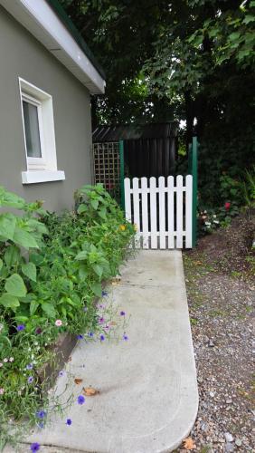 a white fence next to a house with flowers at The Green Room in Killarney