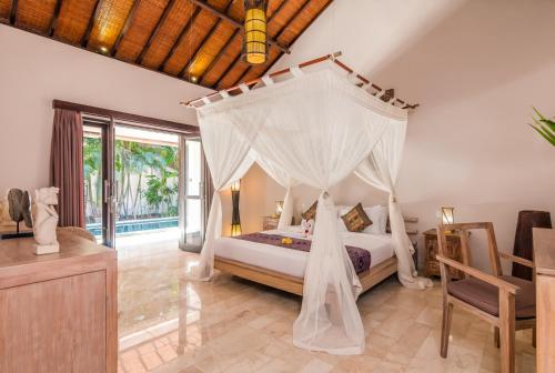 a bedroom with a bed with a canopy at Villa Can Barca in Seminyak