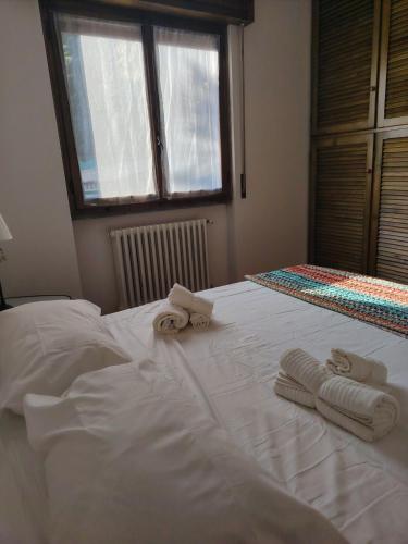 a white bed with towels on top of it at Villa Bella Porto Valtravaglia in Porto Valtravaglia