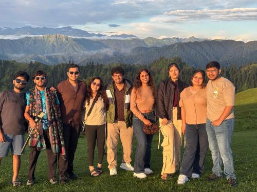 a group of people posing for a picture on a mountain at Apple Land by Naavagat in Jibhi