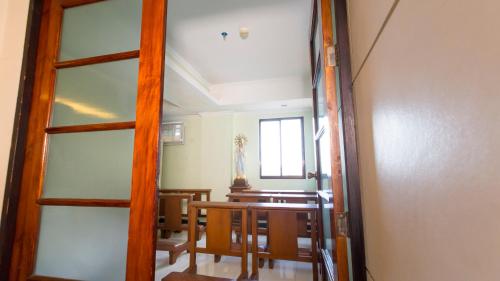 a room with a table and chairs and a window at One Lourdes Dormitel in Iloilo City