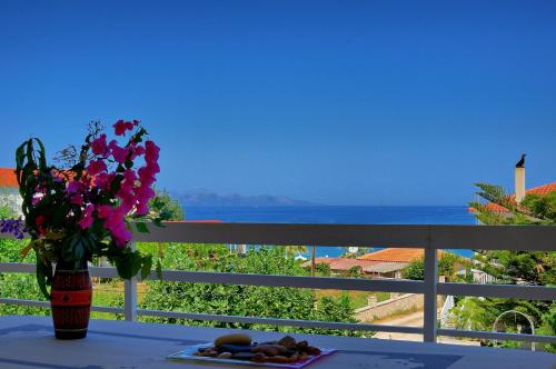 a table with a vase of flowers and a plate of food at Drosia Apartments in Kypseli