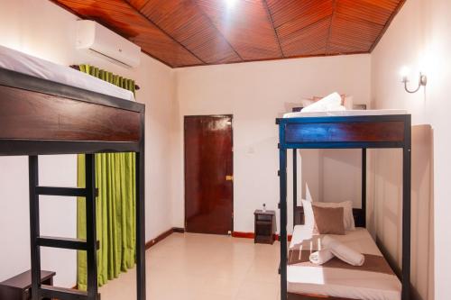 a room with two bunk beds and a hallway at Tribe Hostel in Kandy