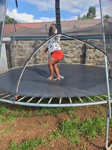 a girl is playing on a trampoline at Nyodera Homes Furnished Apartments in Oyugis