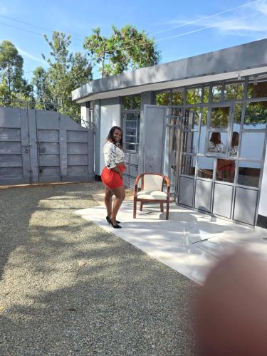 a woman standing in front of a house at Nyodera Homes Furnished Apartments in Oyugis