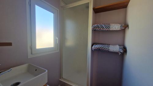 a bathroom with a sink and a window and a mirror at Camping Albox in Albox