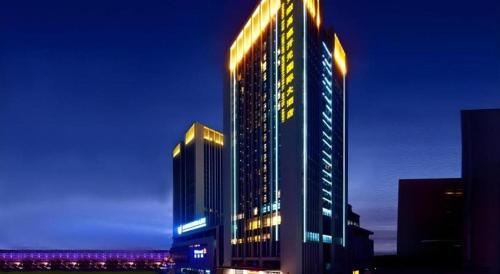 a tall building with lights on it at night at Gaosu New Century Hotel International Anhui in Hefei