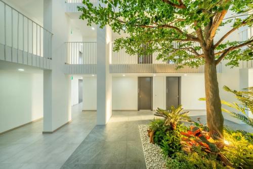 a hallway with a tree in the middle of a building at SHIN Patara Living Hotel in Bangkok