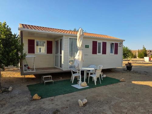 a small caravan with a table and chairs in front of it at Camping Albox in Albox