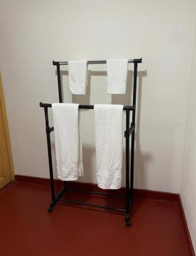 a towel rack with white towels on it at Sena's Cave Villa in Dambulla