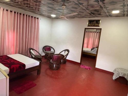 a room with a bed and chairs and a mirror at Sena's Cave Villa in Dambulla