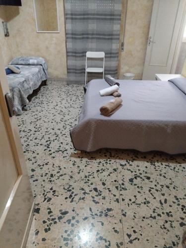 a bedroom with two beds and a patterned floor at low cost airport room catania bagno privato in camera 800 mt aeroporto in CTA